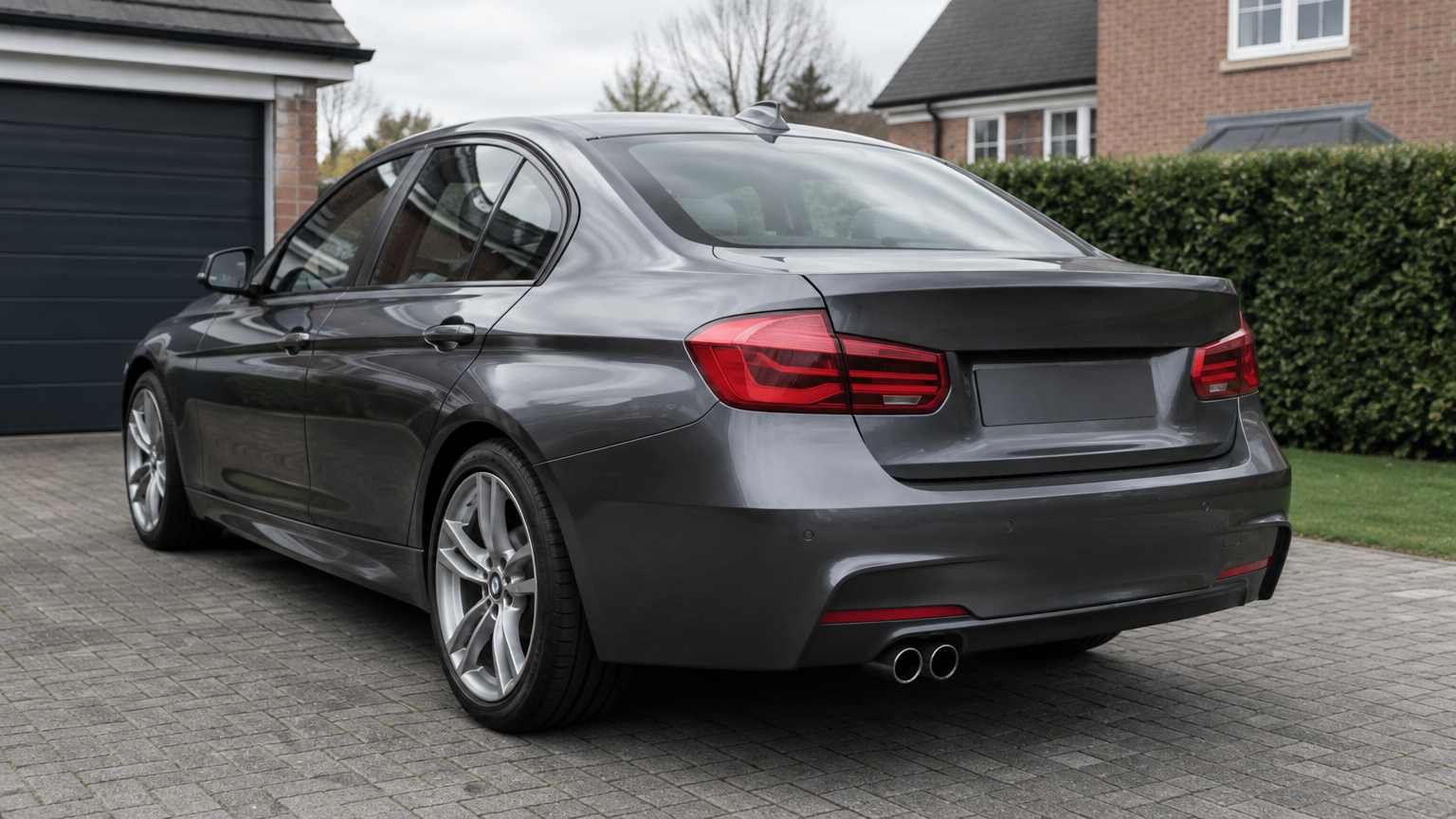 Illustrative grey BMW 320d saloon parked on a residential driveway in England.